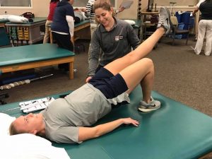 therapist assisting patient with therapy exercises