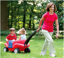 rebecca pulling her two grandchildren in a cart through the grass