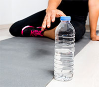 yoga student reaching for her water bottle