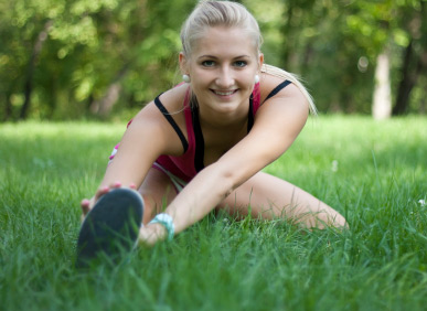 young woman stretching in the grass